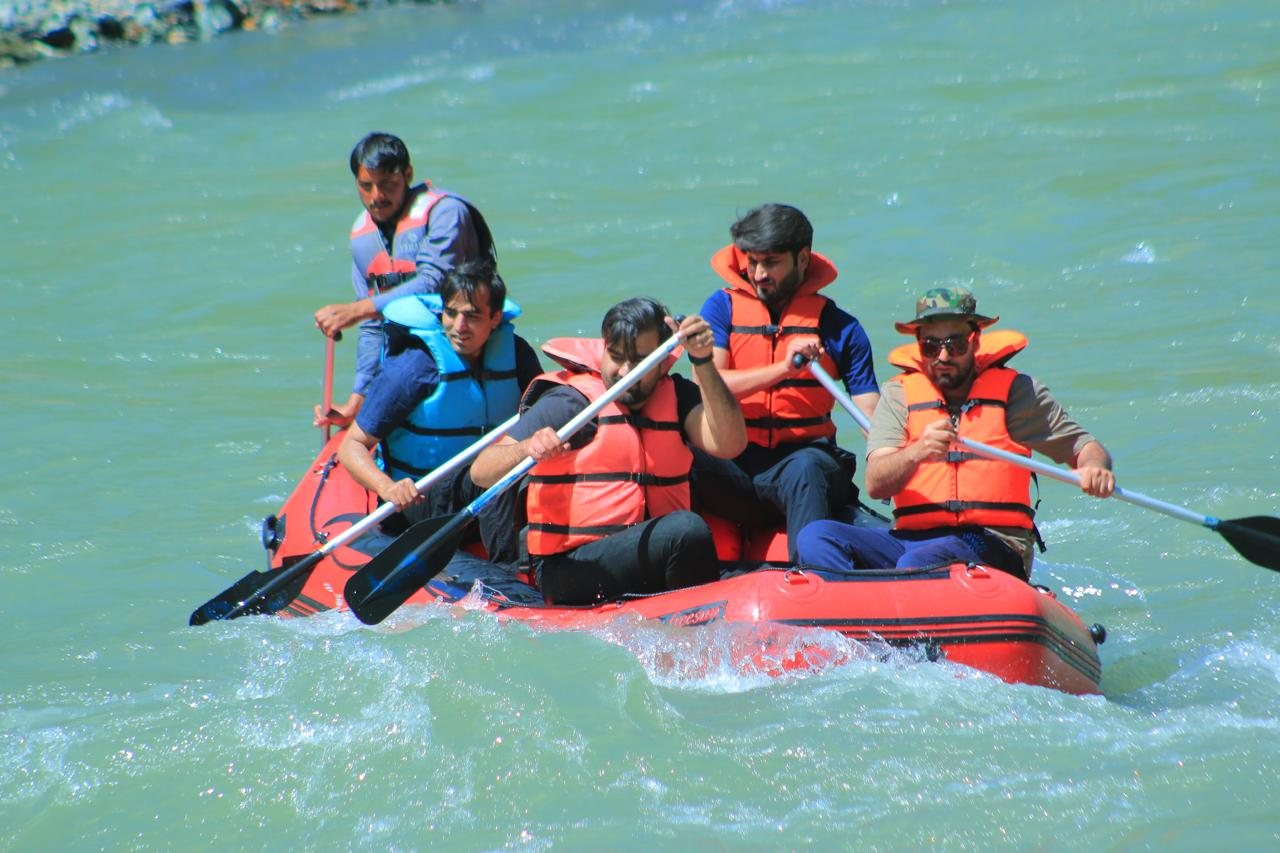 Guests paddling a raft through the jade water of the Kunhar